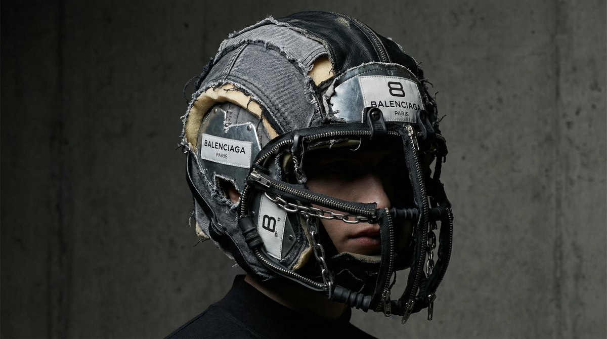 [BRAND]. A hyperrealistic editorial photo of a figure wearing a unique helmet or mask that embod 2