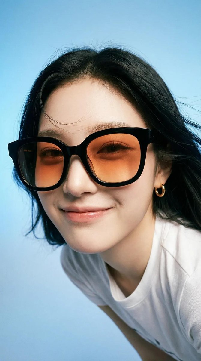 Photorealistic editorial portrait of a smiling woman using the exact same face from the referenc